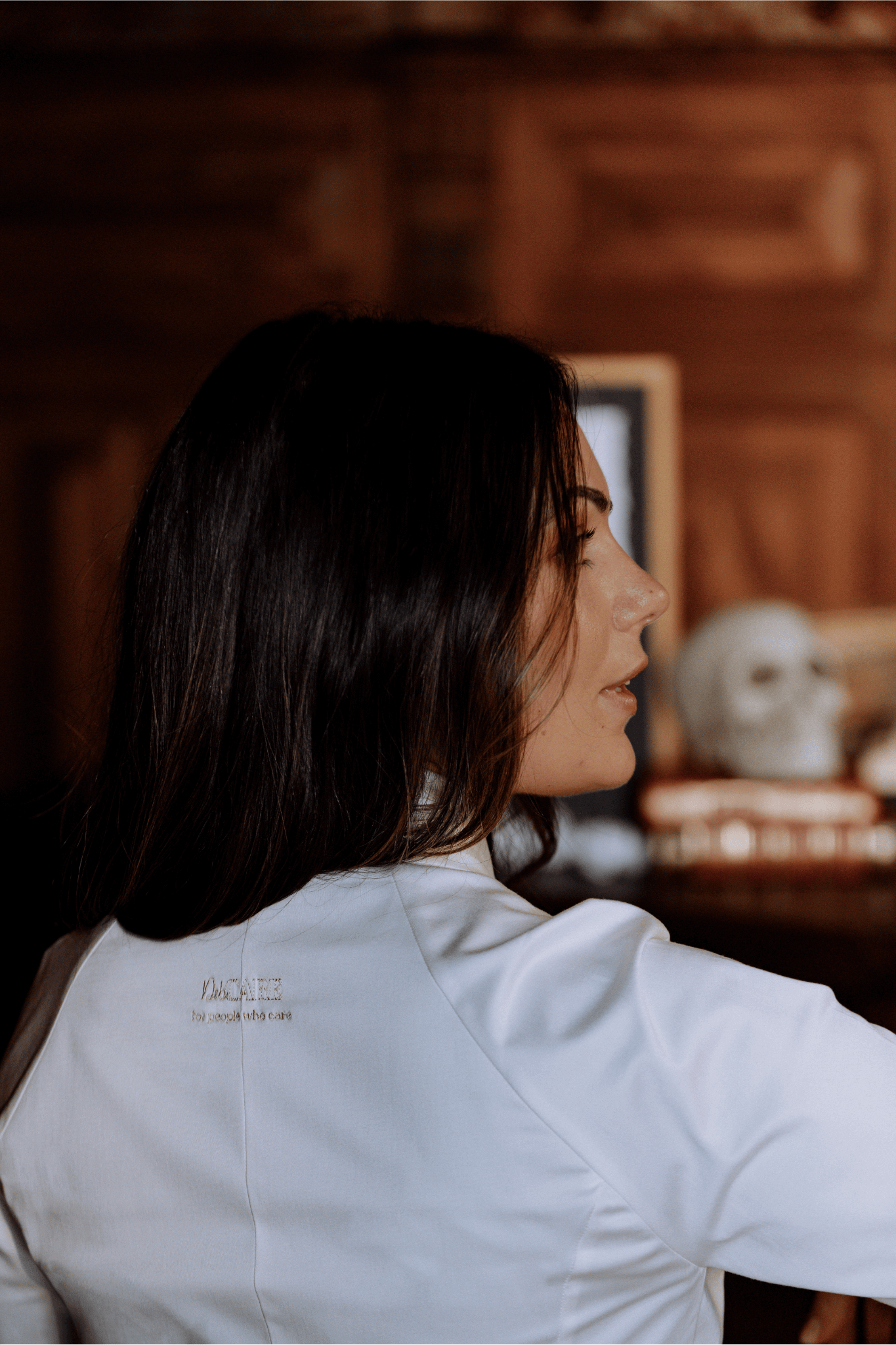 Profile view of a woman in a white medical coat, symbolizing elegance and resilience in women's healthcare.