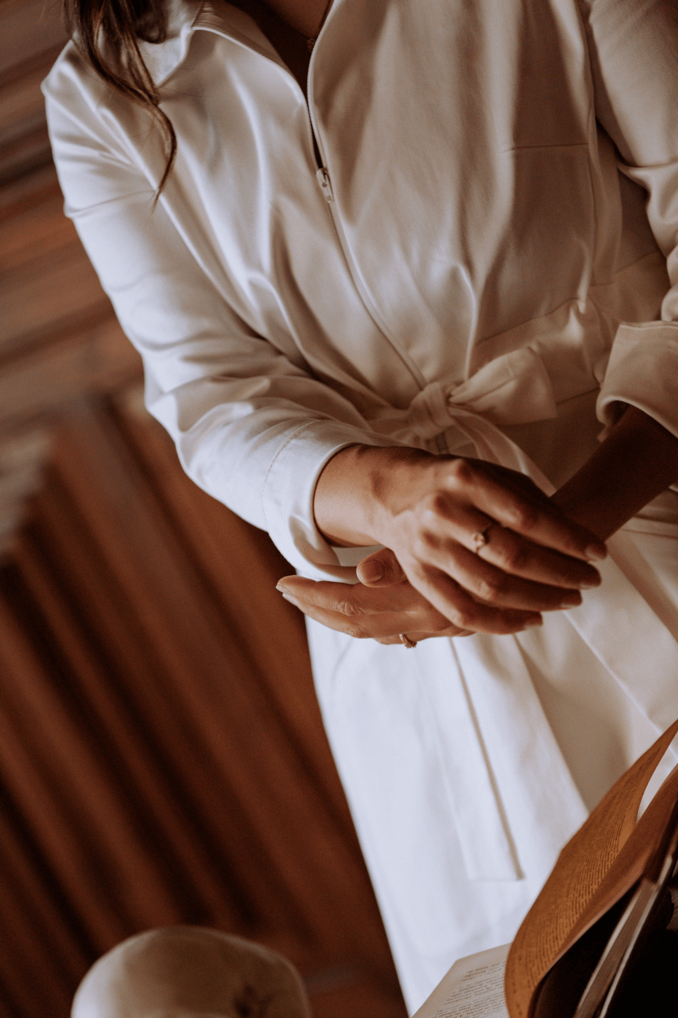 Woman wearing a white bata with a structured collar and adjustable belt, symbolizing elegance and functionality.